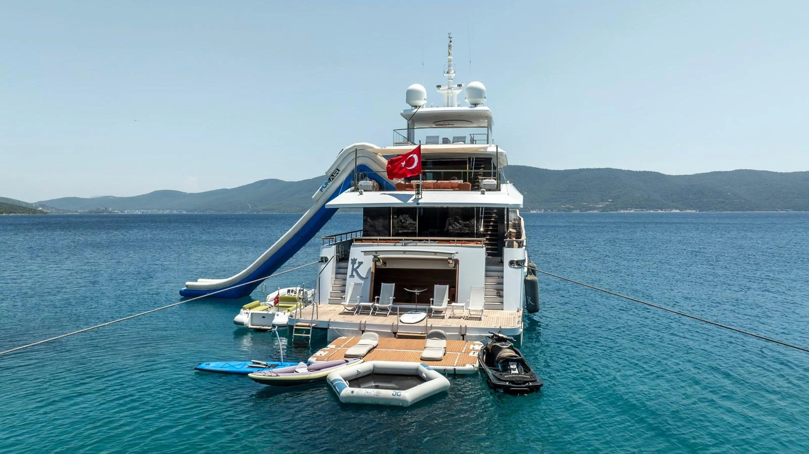 The yacht's aft deck features a variety of water toys and a slide, perfect for enjoying the open sea. aboard K Yacht for Sale