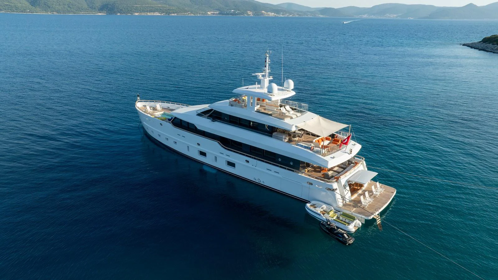 A luxurious yacht is anchored in serene blue waters, showcasing its elegant design and spacious decks. aboard K Yacht for Sale
