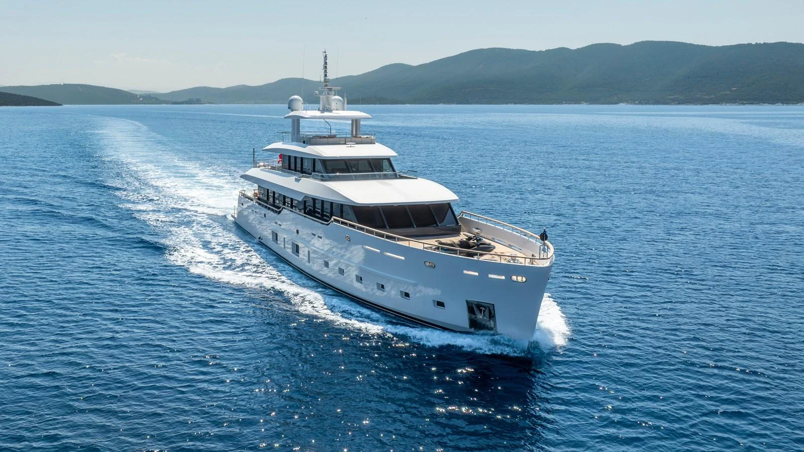 A sleek and modern yacht cruises through clear blue waters, showcasing its elegant design. aboard K Yacht for Sale