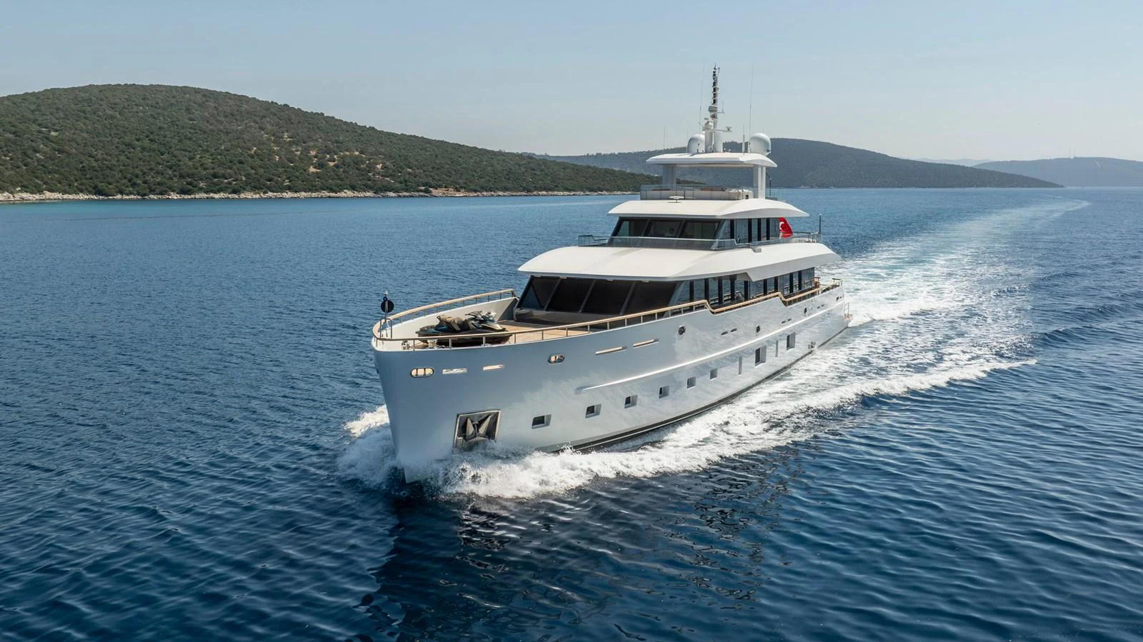 A sleek yacht cruises through clear blue waters, showcasing its elegant design and luxurious features. aboard K Yacht for Sale