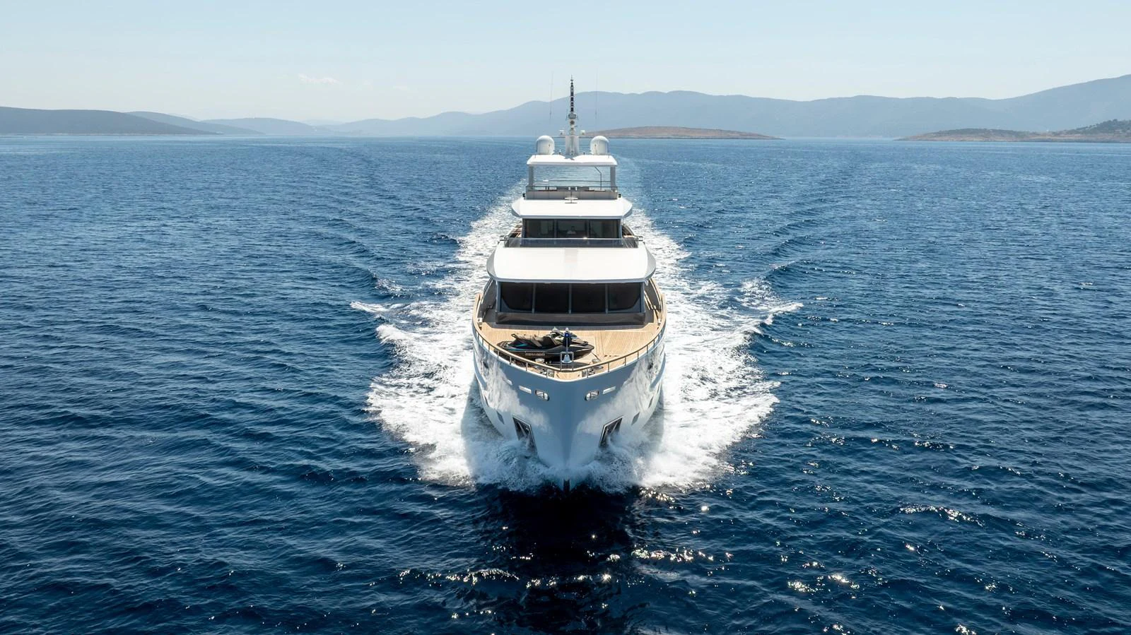A luxurious yacht cruises through the open sea, leaving a trail of white wake behind. aboard K Yacht for Sale