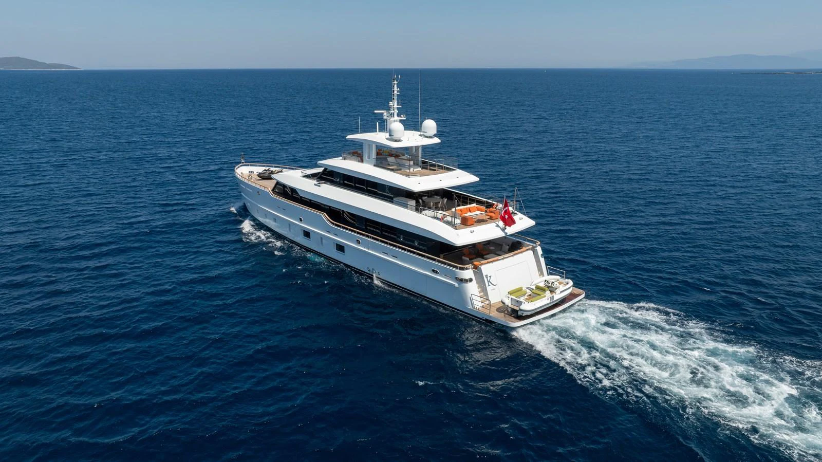 A luxurious yacht cruises through the open sea, showcasing its sleek design and spacious decks. aboard K Yacht for Sale