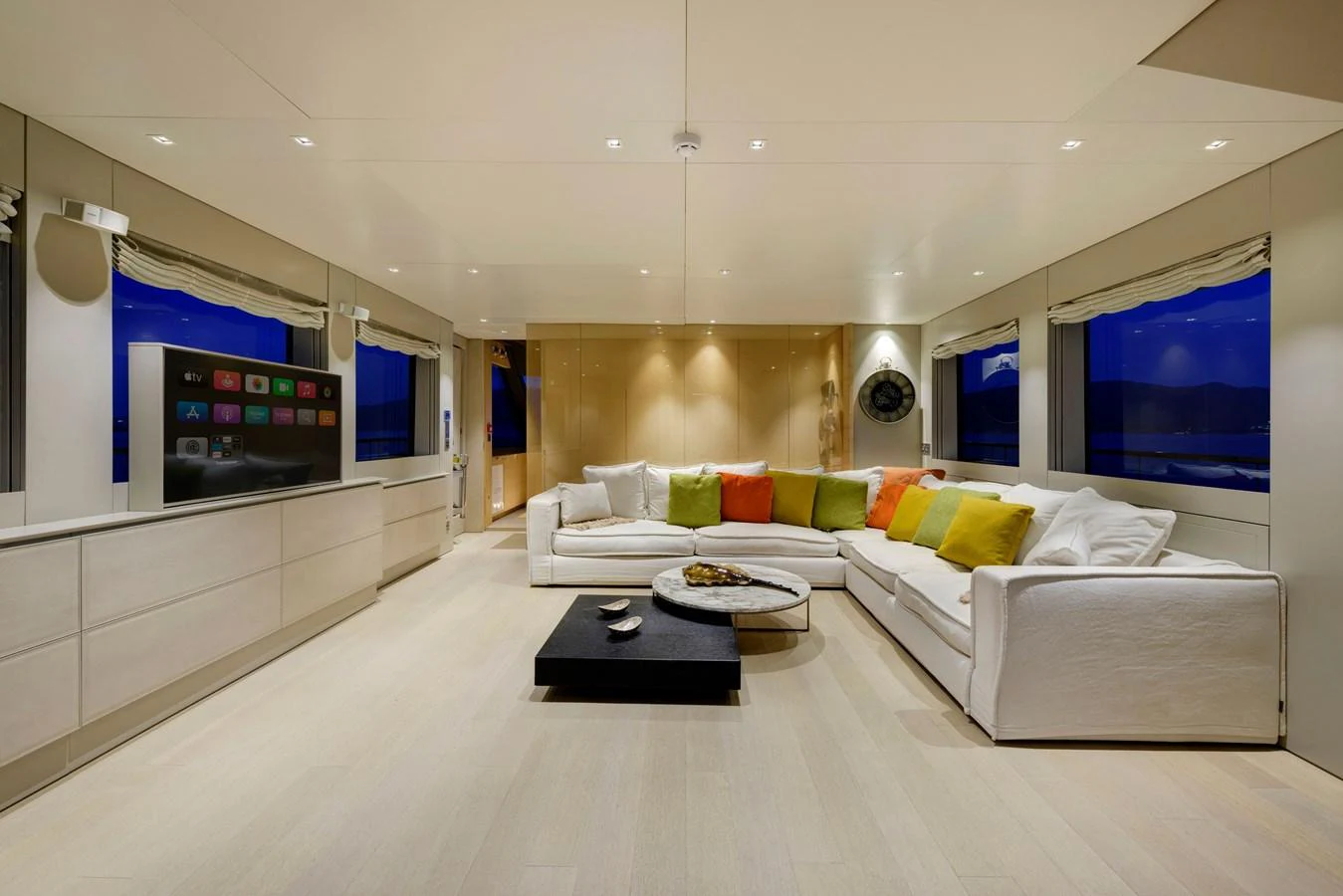 The spacious salon features a large, comfortable seating area with colorful cushions and a modern entertainment system. aboard K Yacht for Sale