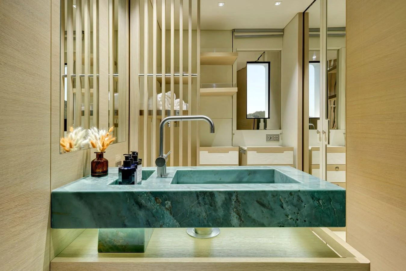 A luxurious bathroom with a modern green marble sink and elegant wooden accents. aboard K Yacht for Sale
