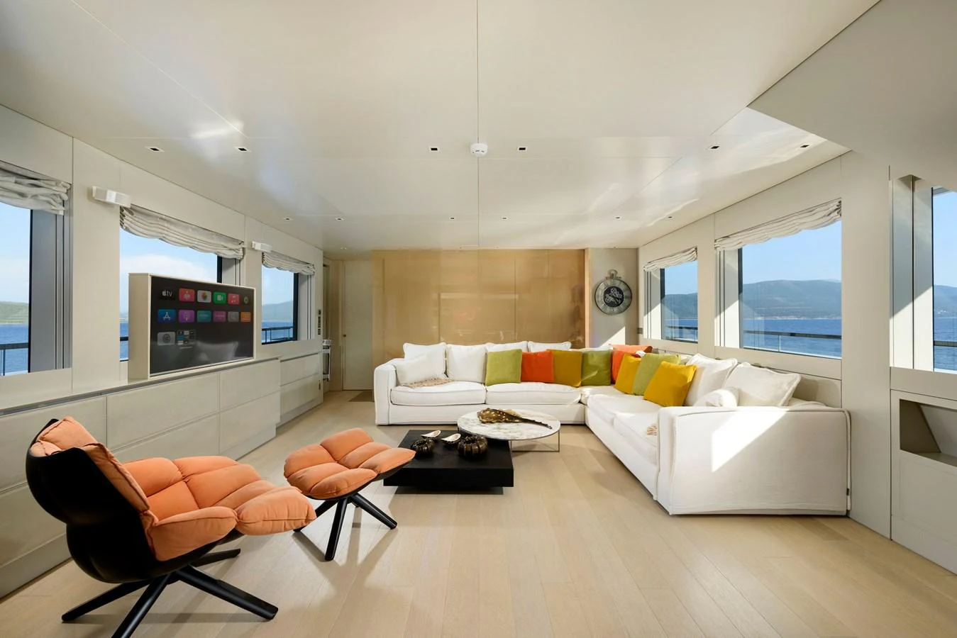 The salon features modern furnishings with vibrant accents and panoramic windows offering stunning sea views. aboard K Yacht for Sale