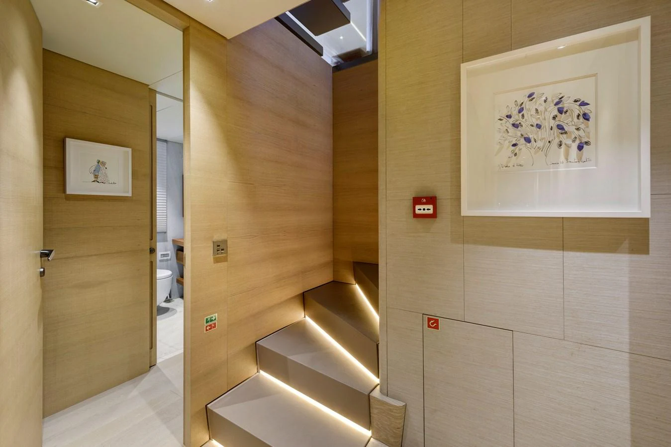 The interior features a modern staircase with elegant lighting and tasteful artwork on the walls. aboard K Yacht for Sale