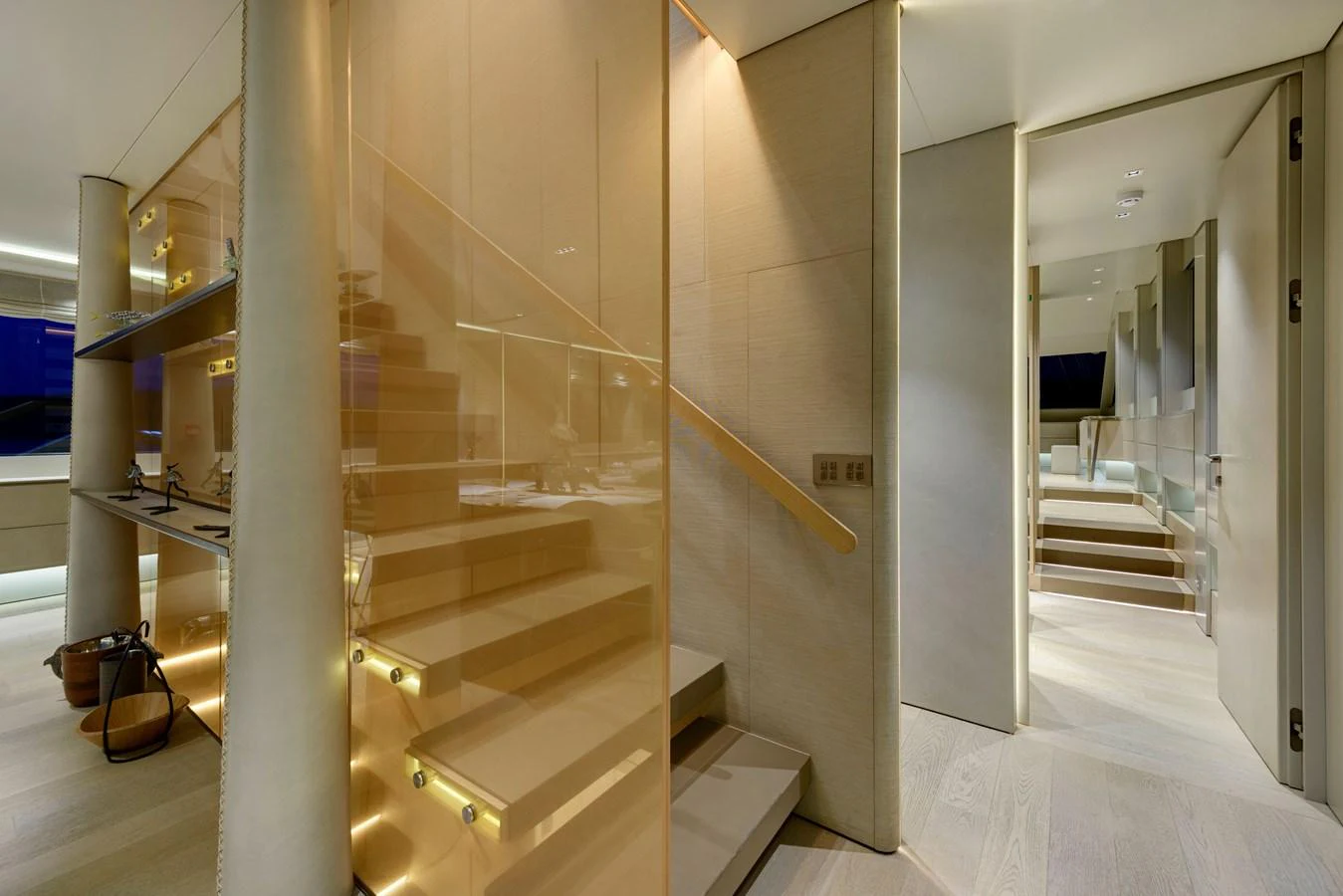 The yacht's interior features a modern staircase with glass railings and warm lighting. aboard K Yacht for Sale