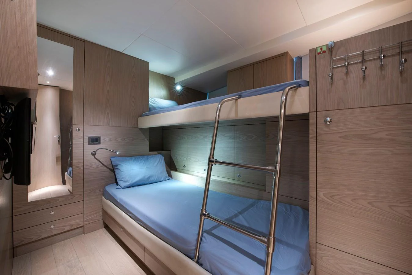 The cozy bunk cabin features modern wood paneling and comfortable bedding. aboard K Yacht for Sale