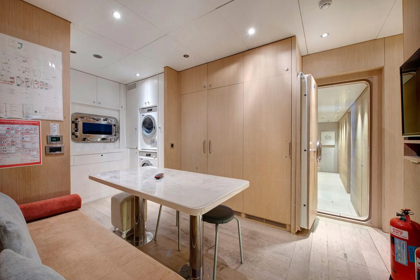 The yacht's interior features a practical and well-organized utility area with a dining table and laundry facilities. aboard K Yacht for Sale