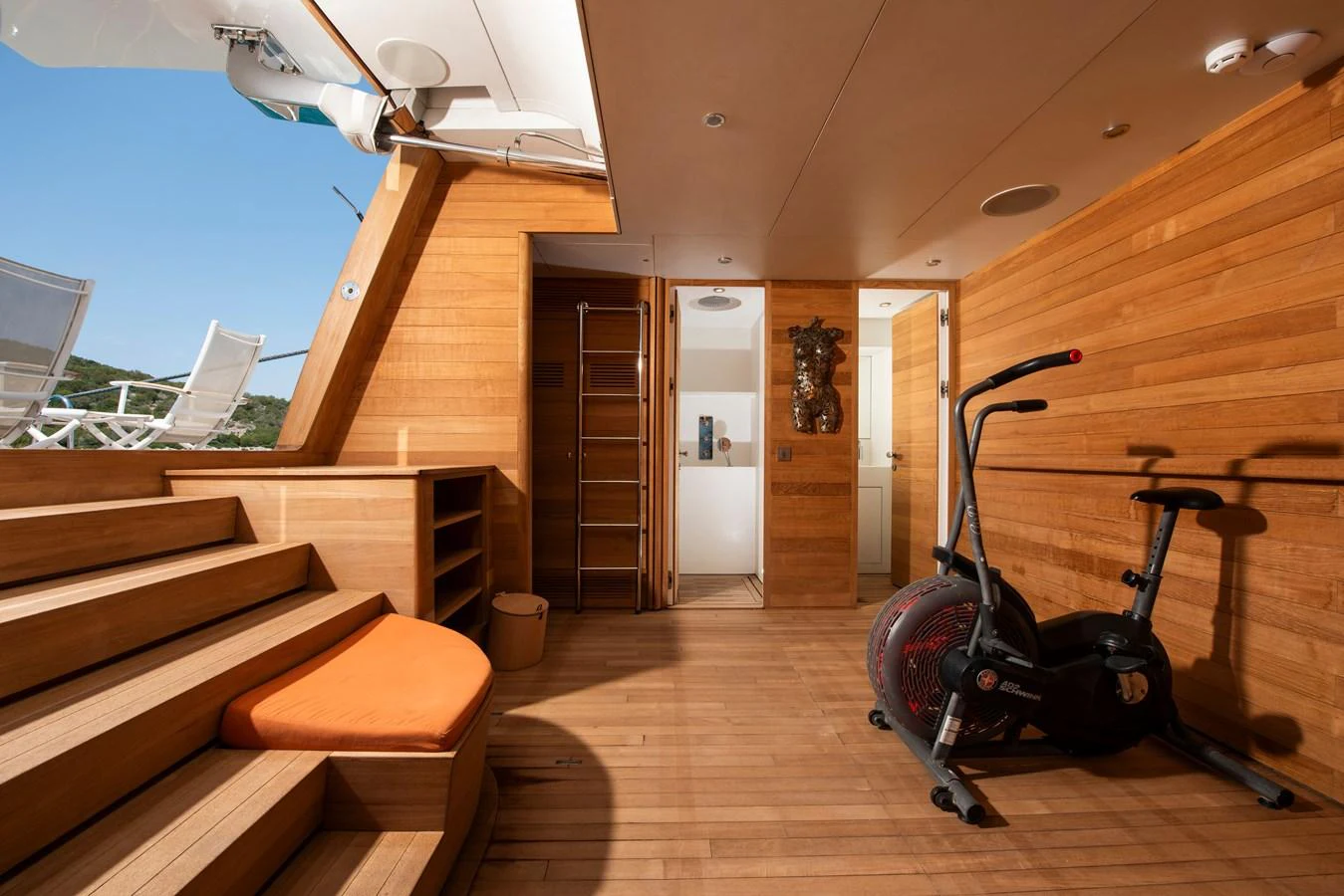 The yacht features a well-appointed gym area with modern equipment and wooden accents. aboard K Yacht for Sale