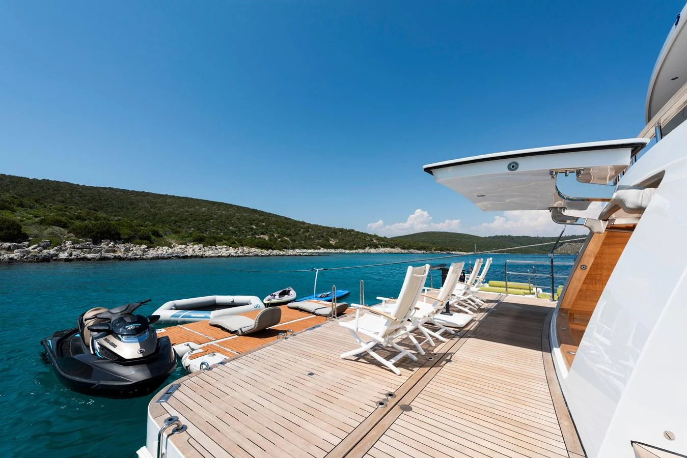 The yacht's swim platform is equipped with lounge chairs and water toys, offering a relaxing space by the water. aboard K Yacht for Sale