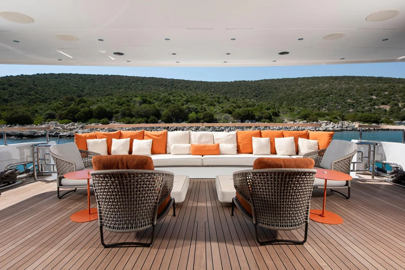 The aft deck features comfortable seating with vibrant orange accents, perfect for relaxation and enjoying the view. aboard K Yacht for Sale