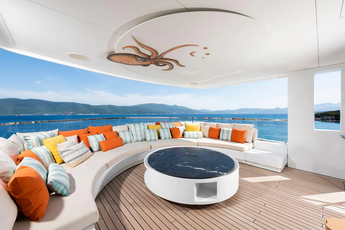 The sundeck features a spacious circular seating area with vibrant cushions and a central table, perfect for relaxation and socializing. aboard K Yacht for Sale
