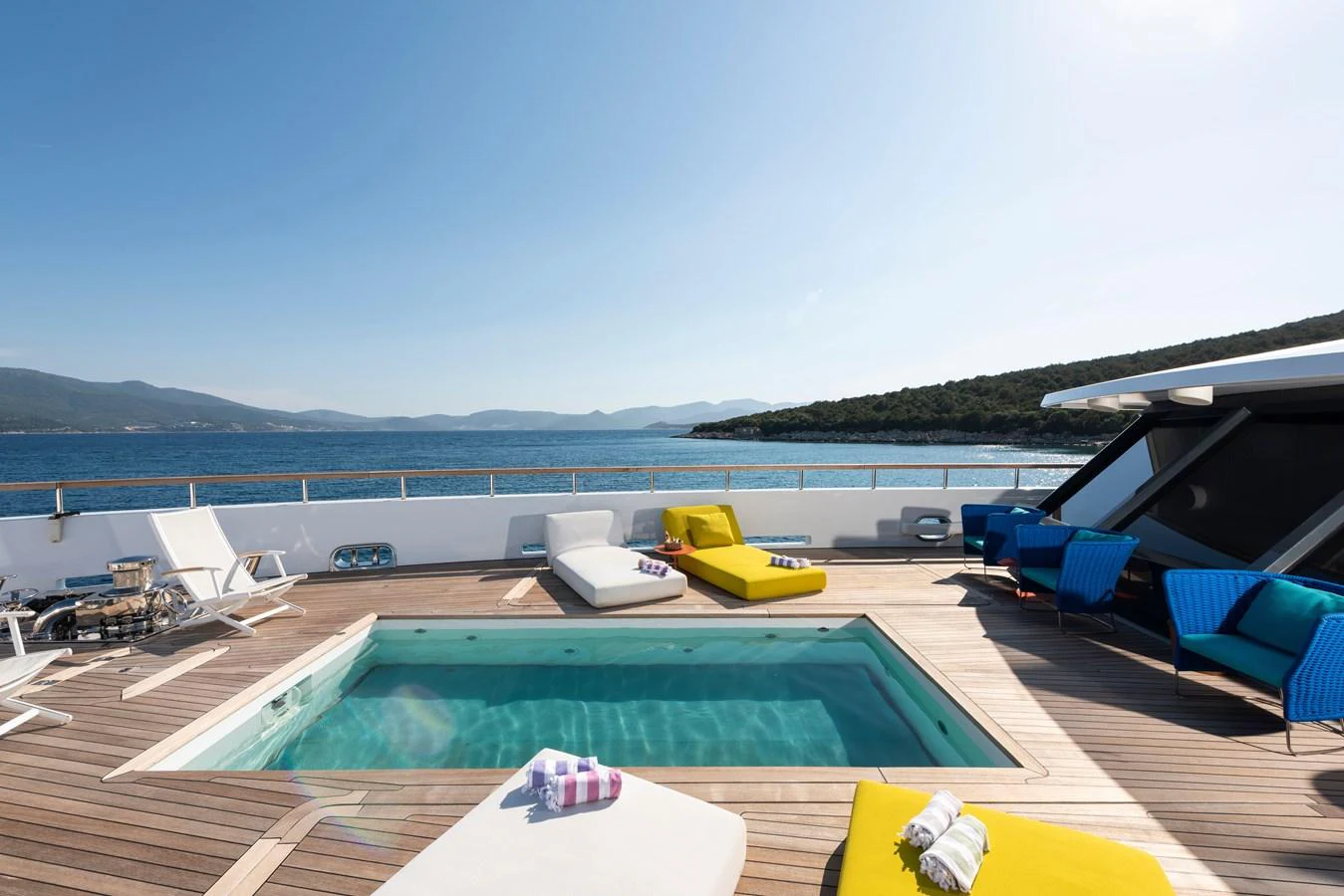 The sundeck features a luxurious pool surrounded by comfortable loungers and stunning ocean views. aboard K Yacht for Sale