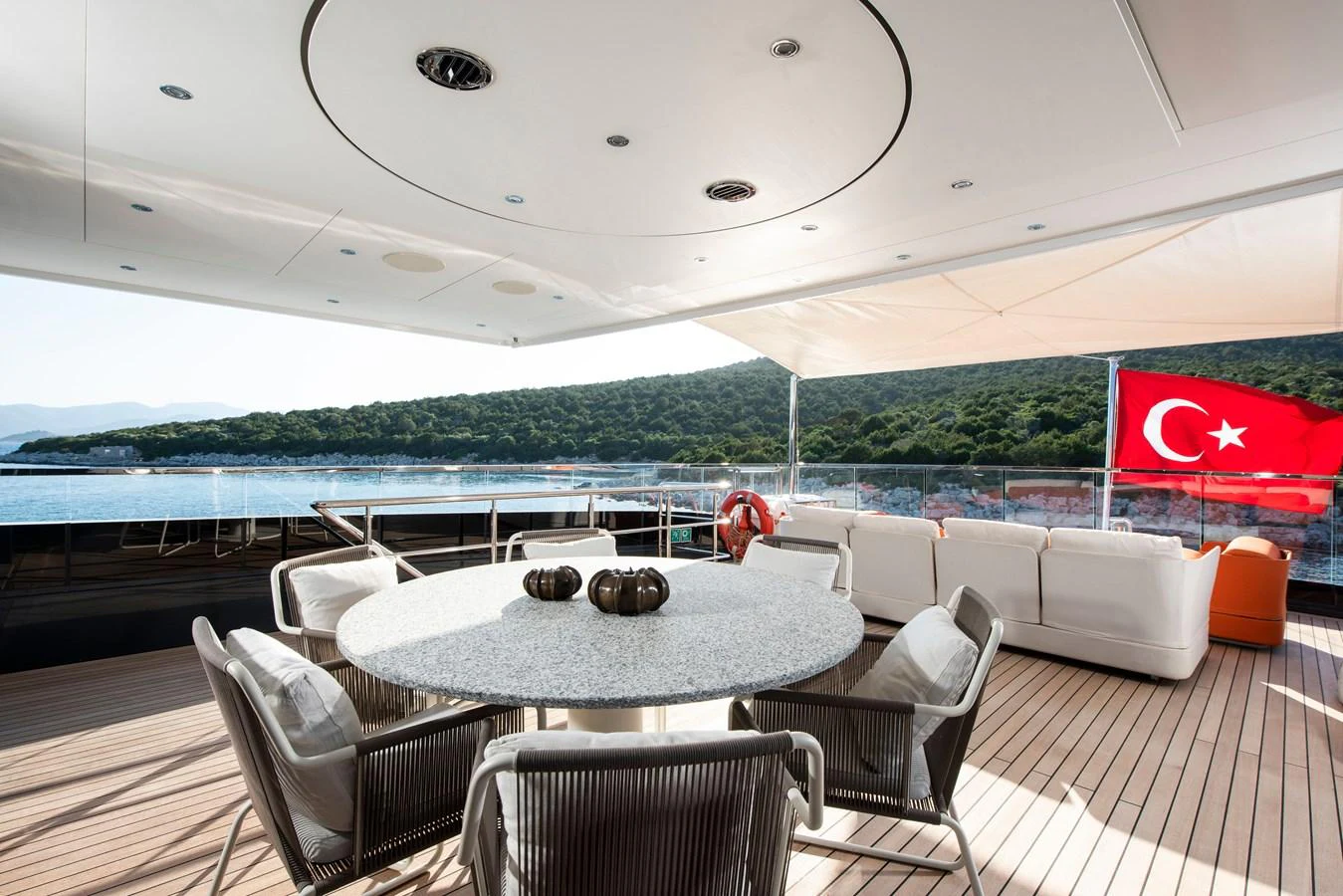 The aft deck features a stylish dining area with comfortable seating and scenic views. aboard K Yacht for Sale