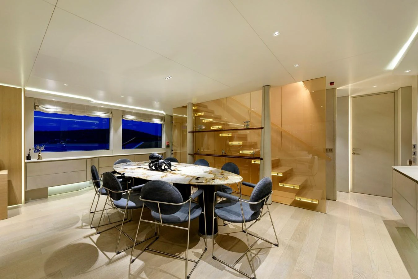 The yacht's dining area features a modern table with elegant seating and ambient lighting. aboard K Yacht for Sale