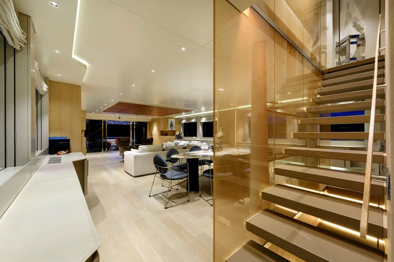 The spacious salon features modern furnishings and an elegant staircase. aboard K Yacht for Sale