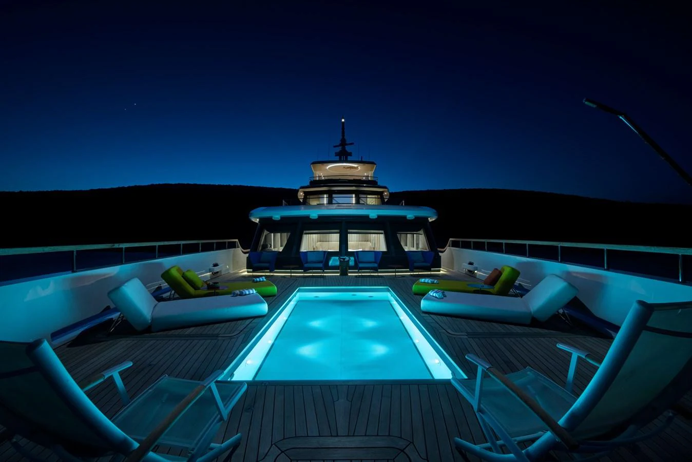 The sundeck features a luxurious pool area illuminated beautifully at night. aboard K Yacht for Sale