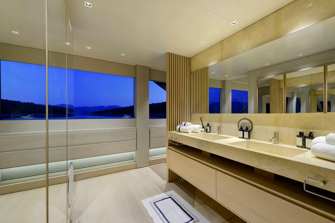A luxurious bathroom with a double sink and a large window offering a scenic view. aboard K Yacht for Sale