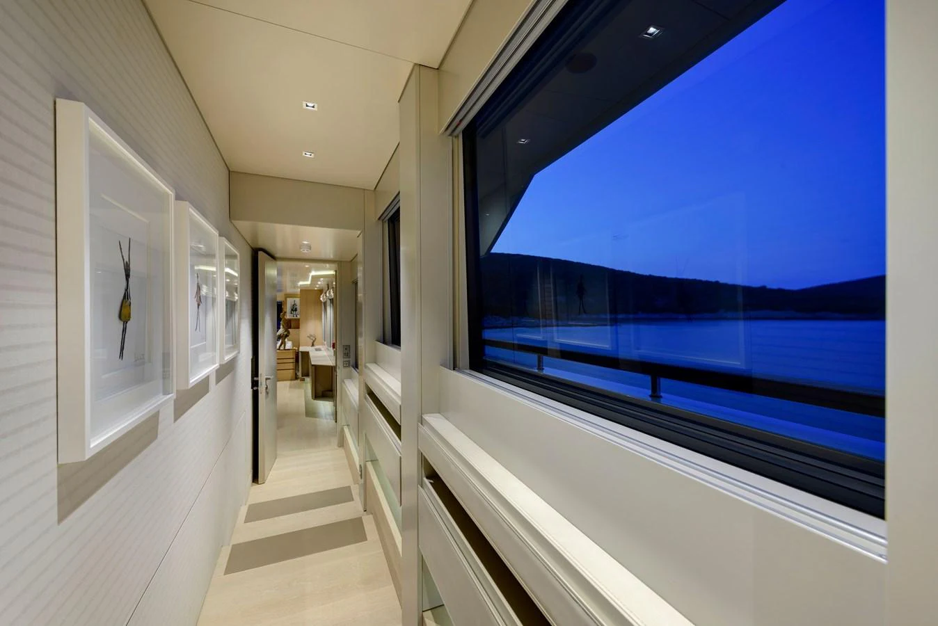 A sleek and modern hallway with large windows offering a serene view of the water. aboard K Yacht for Sale