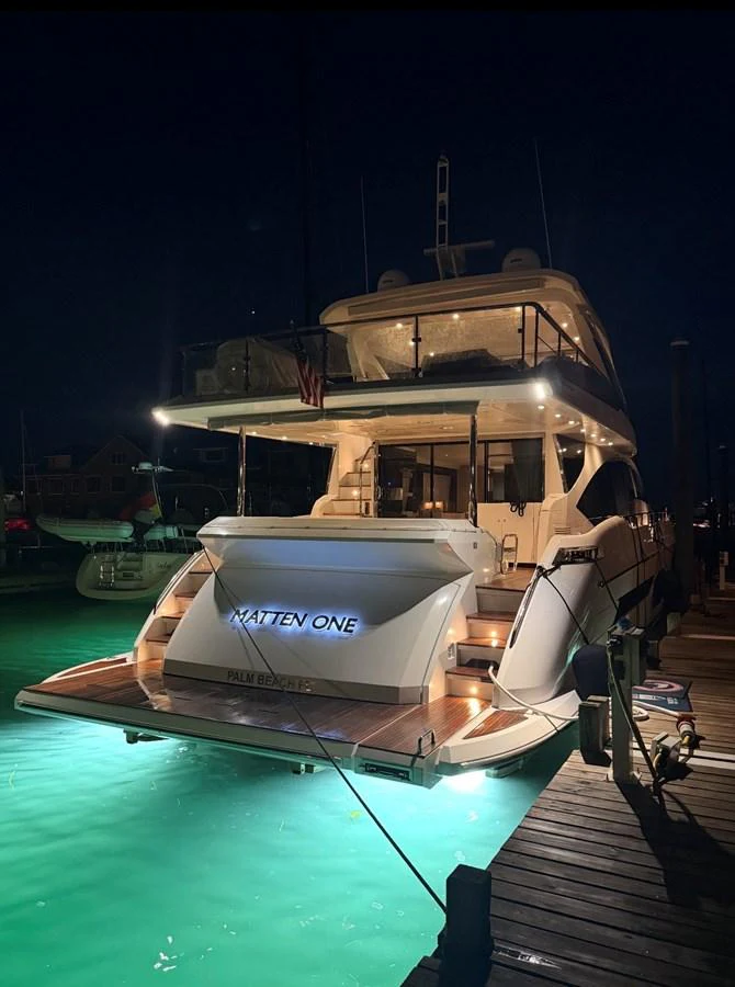The yacht is beautifully illuminated at night, showcasing its elegant aft deck and inviting ambiance. aboard 2022 AZIMUT GRANDE 25M Yacht for Sale