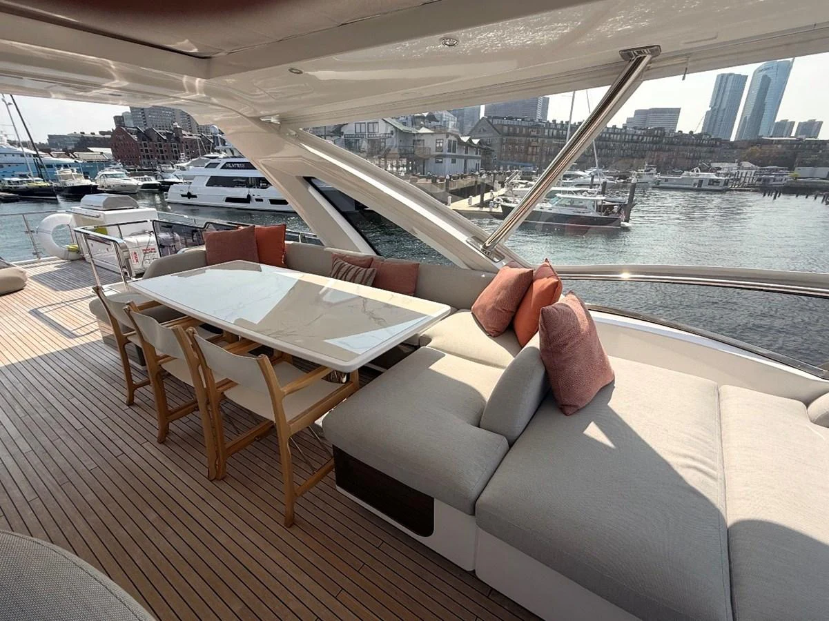 The aft deck features a spacious lounging area with a dining table and comfortable seating, perfect for enjoying waterfront views. aboard 2022 AZIMUT GRANDE 25M Yacht for Sale