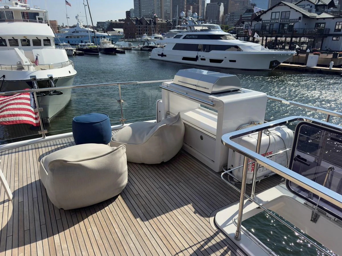 The aft deck features comfortable seating with a scenic marina backdrop. aboard 2022 AZIMUT GRANDE 25M Yacht for Sale