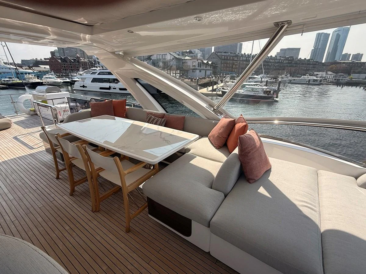 The aft deck features a stylish dining area with a large table and comfortable seating, perfect for alfresco meals with a view of the marina. aboard 2022 AZIMUT GRANDE 25M Yacht for Sale
