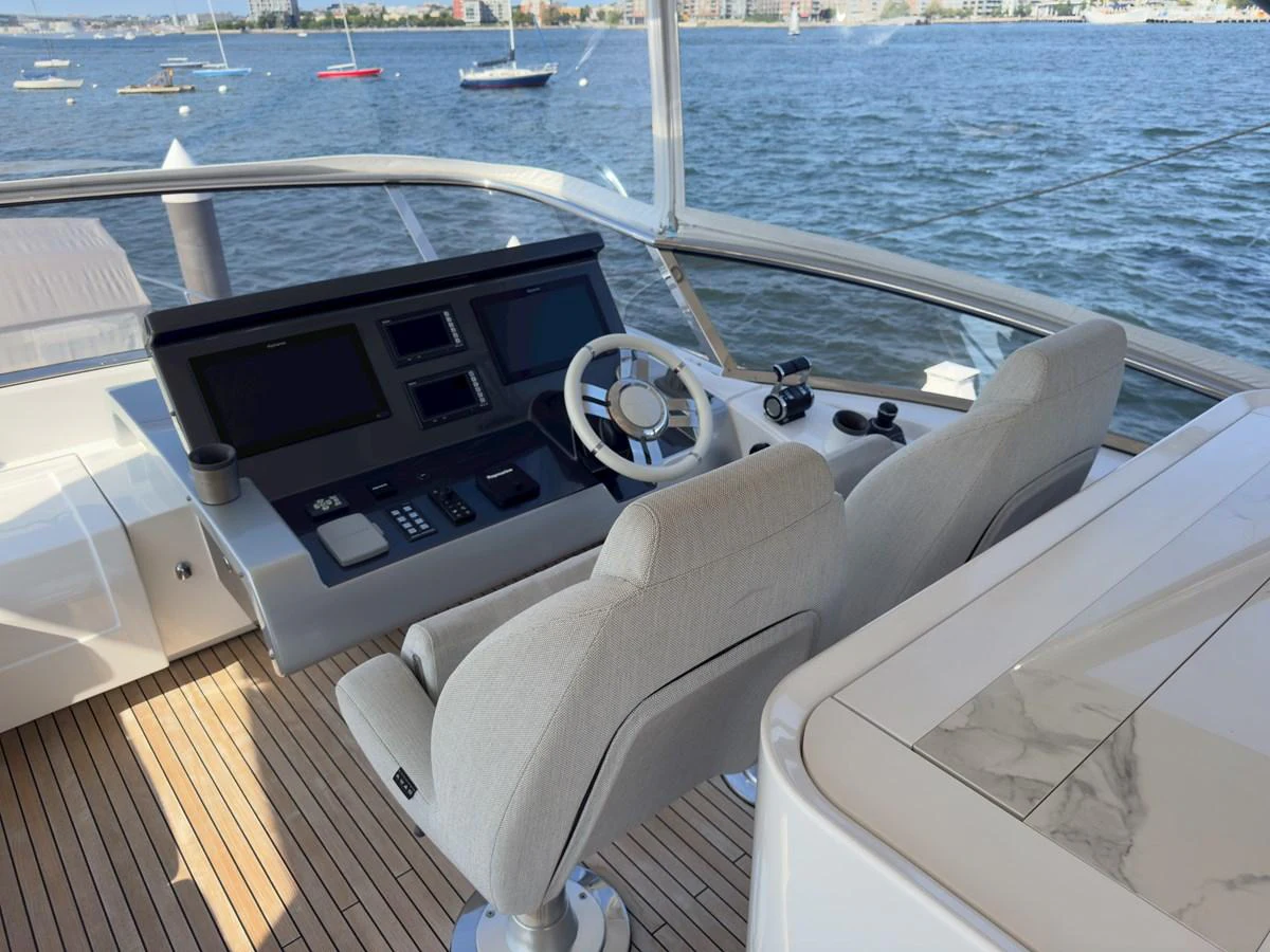 The helm station offers a commanding view with modern navigation equipment and comfortable seating. aboard 2022 AZIMUT GRANDE 25M Yacht for Sale