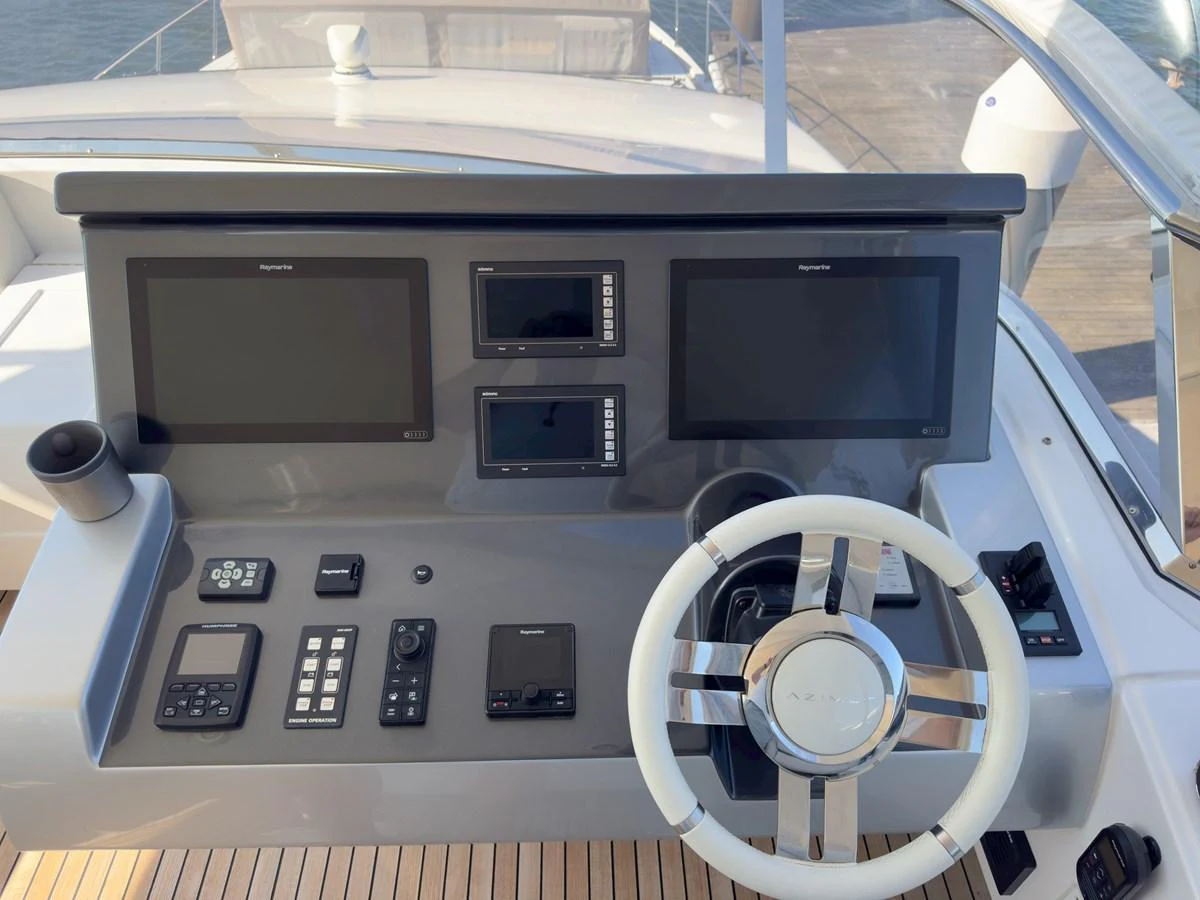 The helm station features modern navigation equipment and a sleek steering wheel. aboard 2022 AZIMUT GRANDE 25M Yacht for Sale
