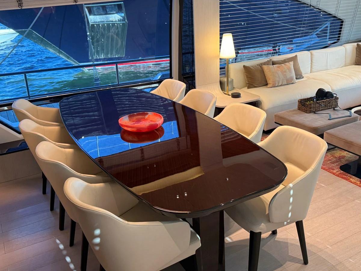 The yacht's dining area features a sleek table with comfortable seating and a view of the water. aboard 2022 AZIMUT GRANDE 25M Yacht for Sale