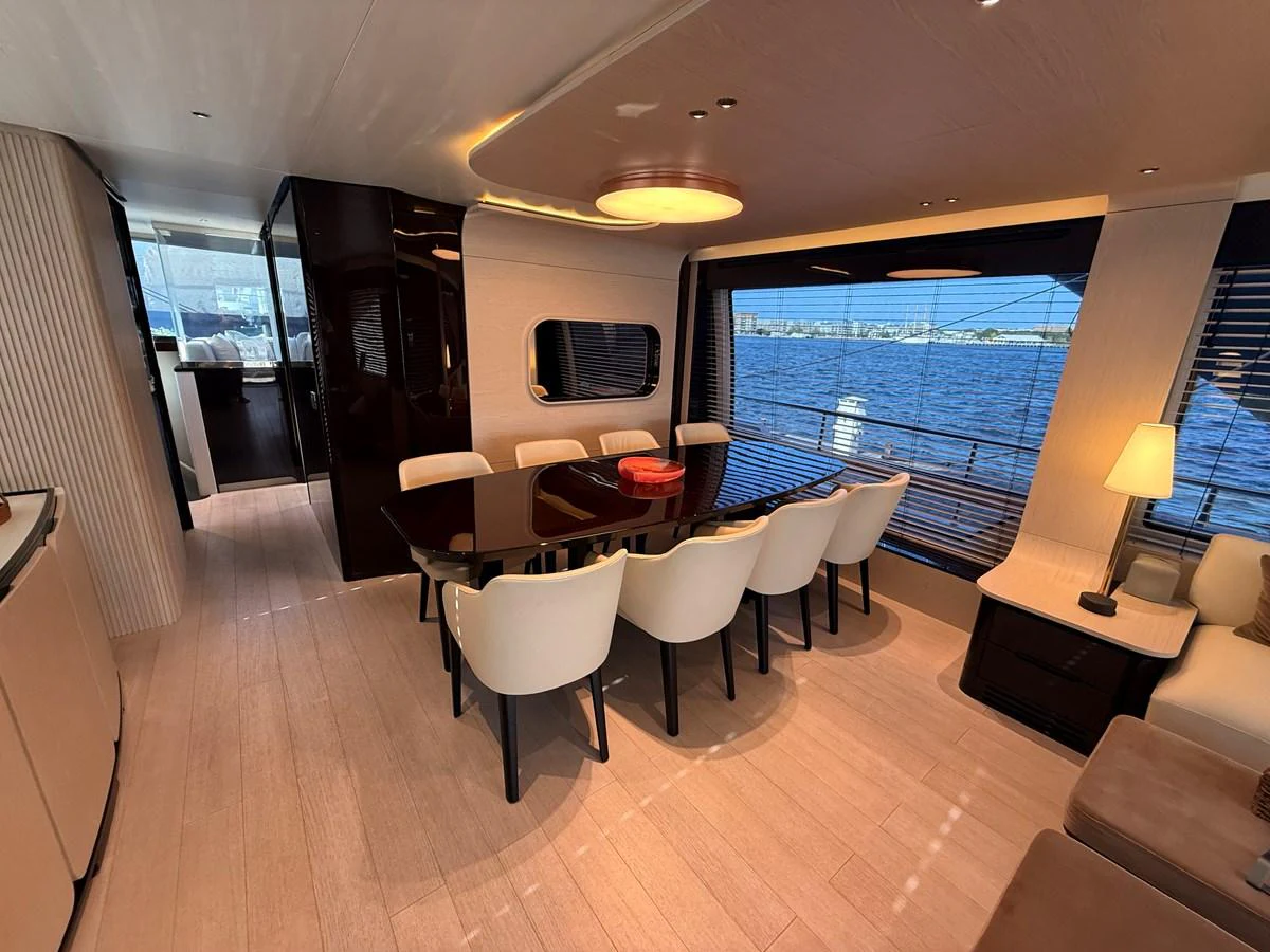 The yacht's dining area features a sleek table with comfortable seating and large windows offering stunning sea views. aboard 2022 AZIMUT GRANDE 25M Yacht for Sale