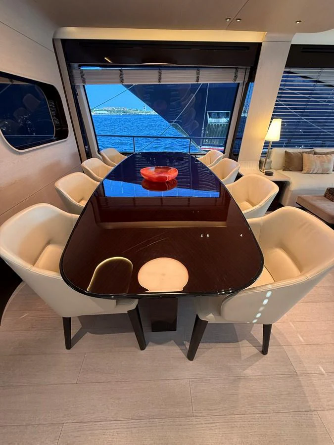 The yacht's dining area features a sleek table with comfortable seating and a view of the water. aboard 2022 AZIMUT GRANDE 25M Yacht for Sale