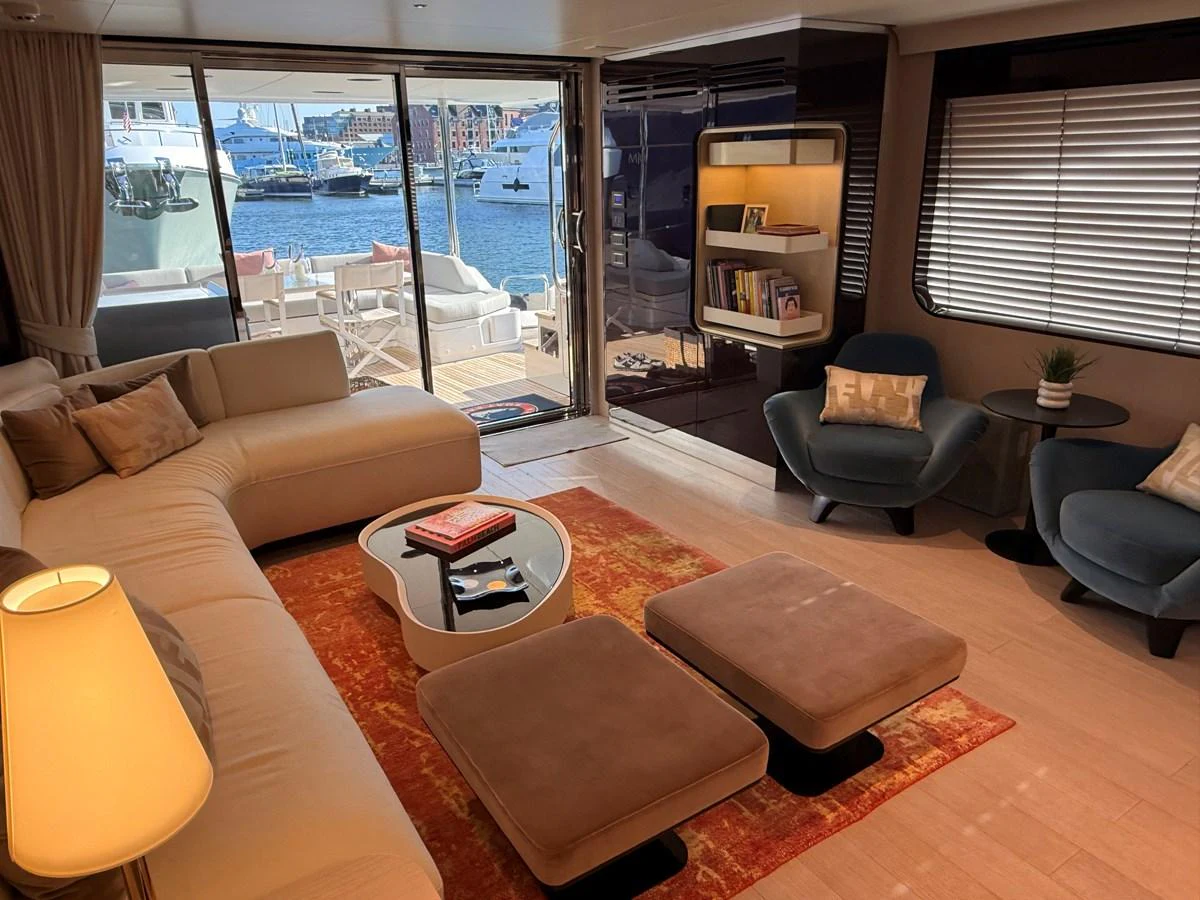 The salon features a comfortable seating area with a view of the marina through large sliding glass doors. aboard 2022 AZIMUT GRANDE 25M Yacht for Sale