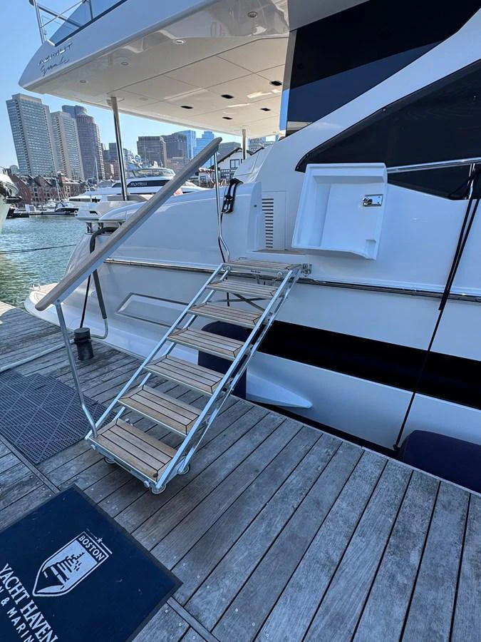 A close-up view of the yacht's boarding ladder and dock area, showcasing the ease of access from the dock. aboard 2022 AZIMUT GRANDE 25M Yacht for Sale