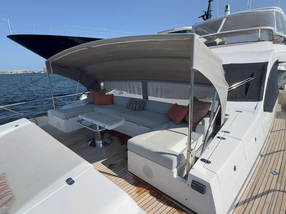The aft deck features a spacious seating area with a retractable canopy for shade. aboard 2022 AZIMUT GRANDE 25M Yacht for Sale