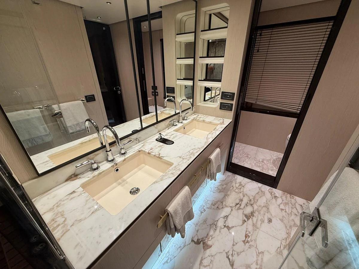 The yacht's bathroom features a luxurious double sink vanity with marble countertops and modern fixtures. aboard 2022 AZIMUT GRANDE 25M Yacht for Sale