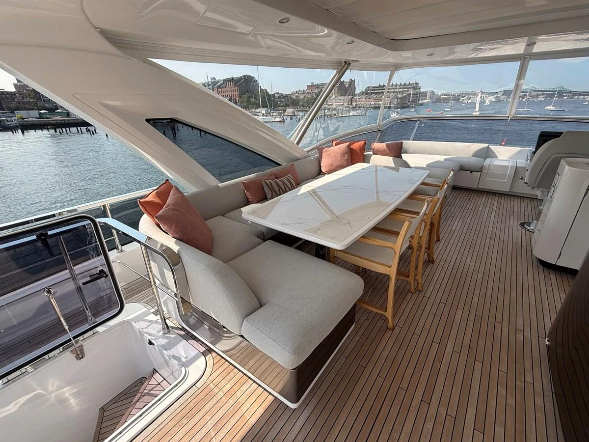 The aft deck features a spacious seating area with a dining table, offering stunning views of the surrounding waters. aboard 2022 AZIMUT GRANDE 25M Yacht for Sale