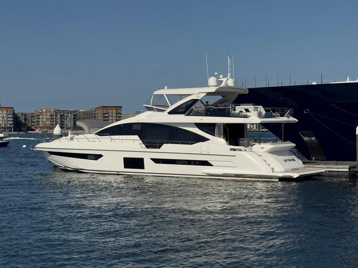 A sleek and modern yacht is docked in a serene marina under a clear blue sky. aboard 2022 AZIMUT GRANDE 25M Yacht for Sale