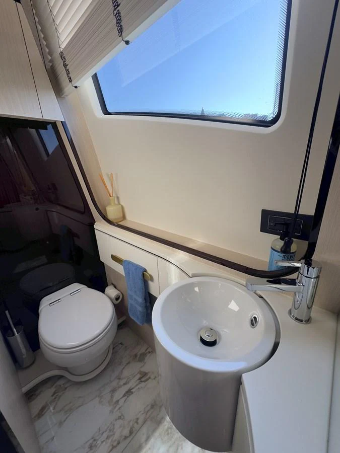 A sleek and modern yacht bathroom with a compact design and ample natural light. aboard 2022 AZIMUT GRANDE 25M Yacht for Sale