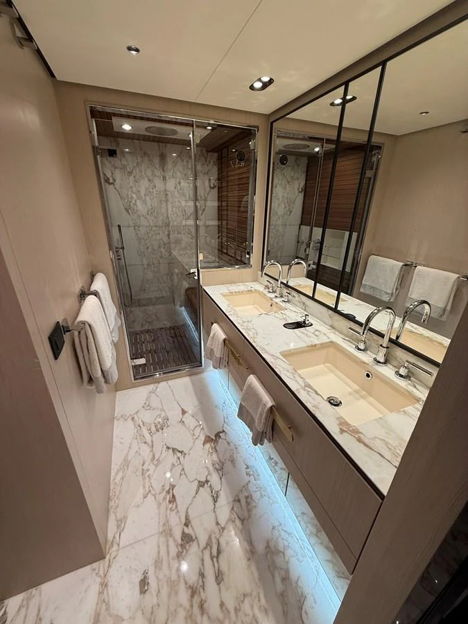 The yacht's bathroom features a luxurious marble design with dual sinks and a spacious shower. aboard 2022 AZIMUT GRANDE 25M Yacht for Sale