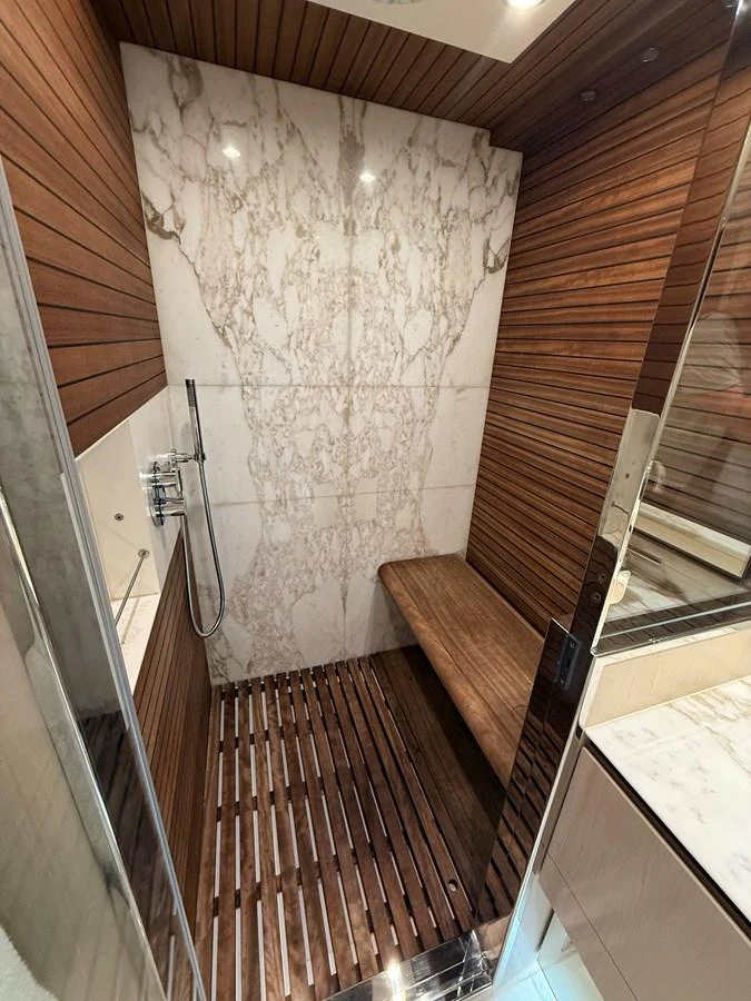 A luxurious yacht shower with elegant wood paneling and marble accents. aboard 2022 AZIMUT GRANDE 25M Yacht for Sale