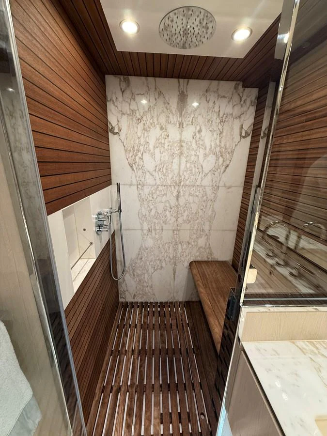 The yacht features a luxurious shower with elegant wood paneling and marble accents. aboard 2022 AZIMUT GRANDE 25M Yacht for Sale