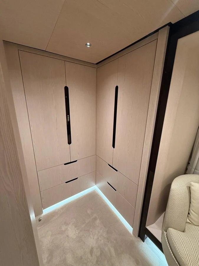 A sleek and modern storage area within the yacht's interior, featuring built-in cabinetry with ambient lighting. aboard 2022 AZIMUT GRANDE 25M Yacht for Sale