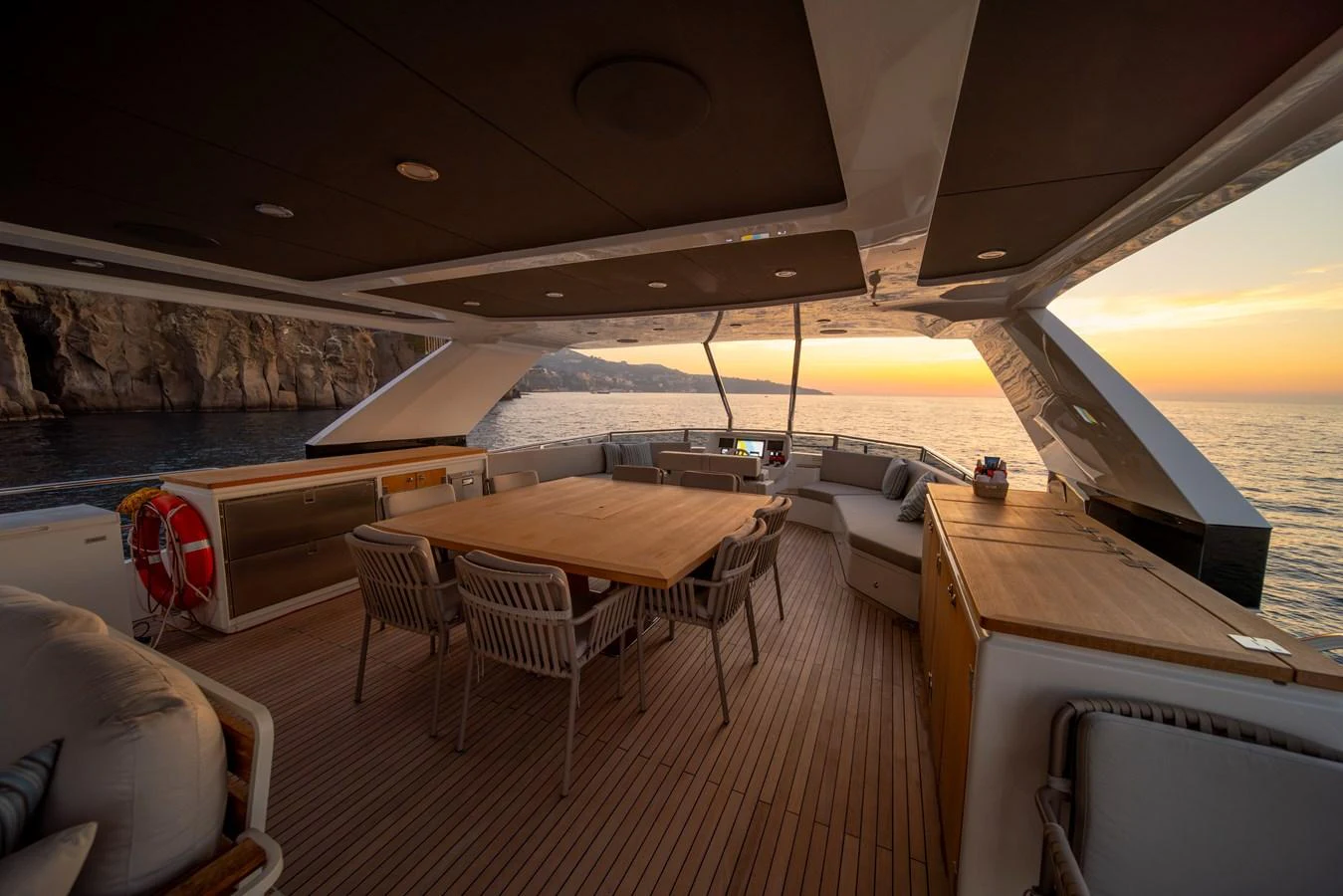 The aft deck offers a spacious and elegant dining area with stunning sunset views over the water. aboard KAMOKA Yacht for Sale