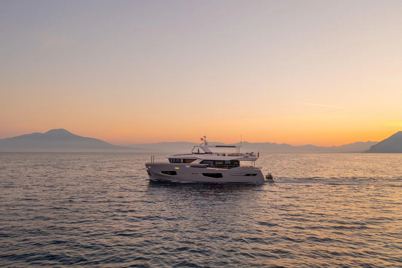 A stunning yacht cruises gracefully on calm waters during a picturesque sunset. aboard KAMOKA Yacht for Sale
