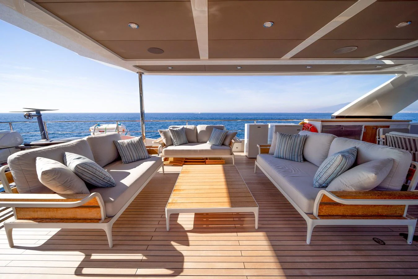 The aft deck offers a luxurious outdoor seating area with comfortable sofas and a stunning ocean view. aboard KAMOKA Yacht for Sale