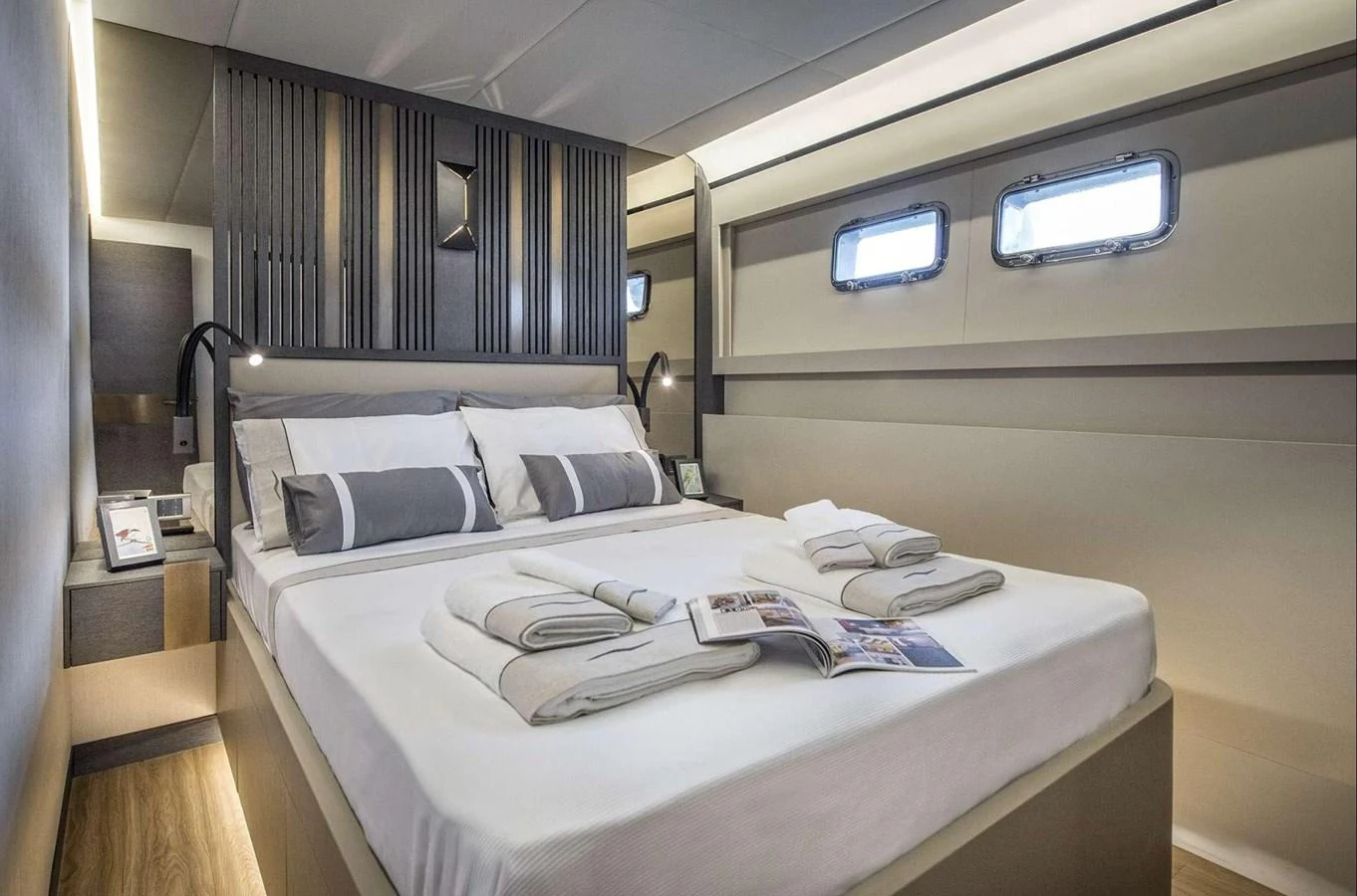 The stateroom features a luxurious bed with elegant linens and modern design elements. aboard KAMOKA Yacht for Sale