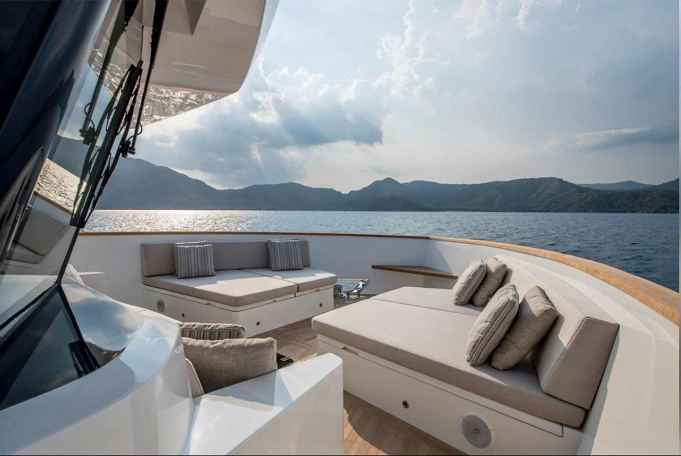 The aft deck offers a serene lounging area with plush seating and stunning sea views. aboard KAMOKA Yacht for Sale