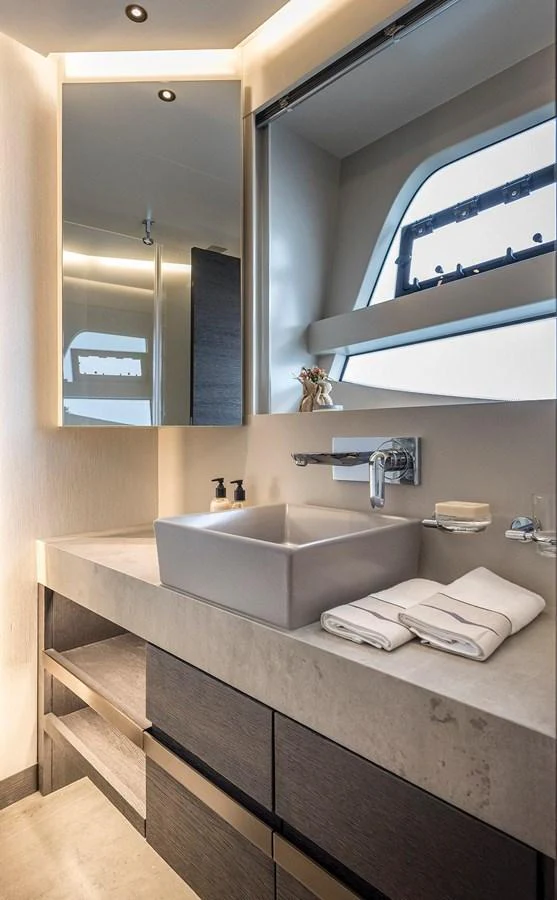 A modern yacht bathroom with sleek fixtures and a large mirror. aboard KAMOKA Yacht for Sale